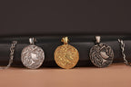 Four ancient silver and gold pendants on a dark surface