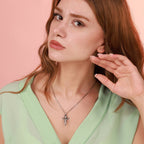 Woman wearing an oxidized silver guardian angel prayer necklace with a pink background