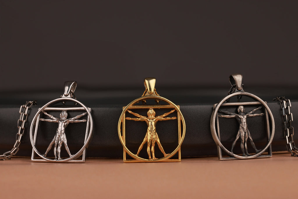 Three pendants featuring the Renaissance Art Vitruvian Man design on a dark background