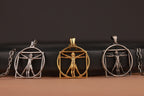 Three pendants featuring the Renaissance Art Vitruvian Man design on a dark background