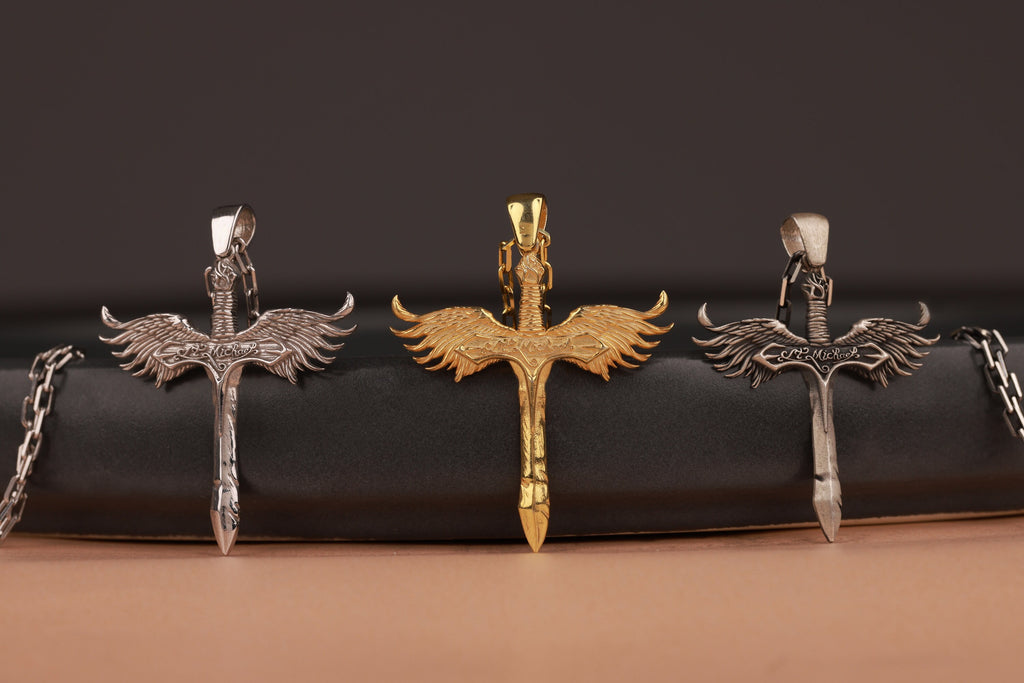 Three sword-shaped pendants on a black surface with a brown background
