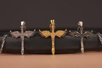 Three sword-shaped pendants on a black surface with a brown background