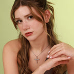 Woman wearing a necklace with a polished sword pendant against a light green background