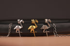 Flamingo-shaped jewelry on a dark background