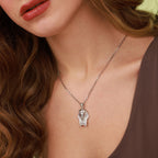 Close-up of a woman wearing a silver Tutankhamun necklace with a pendant.
