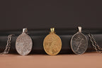 Three tree of life themed pendants on a black and brown background