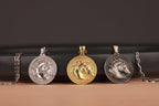 Three horse head coin pendants on chains against a dark background