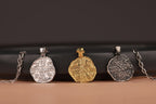 Four pendants on chains against a dark background