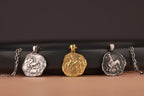 Three animal-themed coin pendants on chains against a dark background
