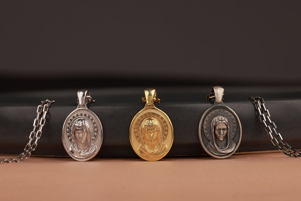 Four virgin mary pendants on black leather with a brown background