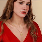 Woman wearing a gold religious necklace with a pendant against a beige background