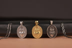 Three Sacred Heart pendants on a black cylindrical object with a brown background