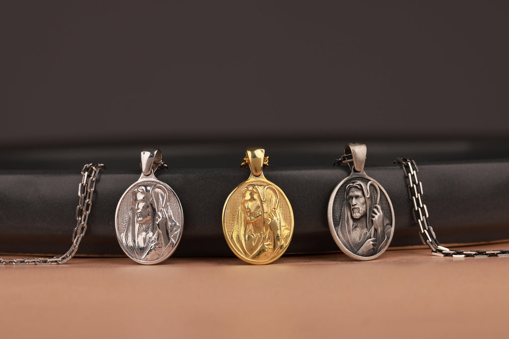 Three good shepherd pendants on chains against a black background