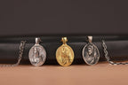 Three good shepherd pendants on chains against a black background