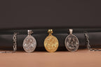 Three holy family pendants on a black and brown gradient background