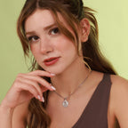 Woman wearing a religious necklace against a light green background
