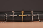 Collection of cross-shaped nail necklaces on a black and brown background