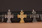 Three St Michael Archangel cross-shaped pendants on a black and brown gradient background