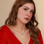 Woman wearing a gold necklace with a cross pendant featuring St Michael against a beige background
