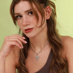 A woman wearing a polished sterling silver St Michael cross pendant necklace