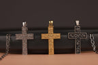 Three rose cross pendants on a dark surface with a brown background