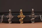 Three "Only God Can Judge Me" cross pendants on a black surface with a brown background