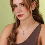 A woman wearing a polished sterling silver necklace with a cross pendant that says "Only God Can Judge Me" 