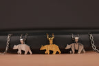 Three bear-shaped pendants on chains against a dark background