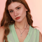 Woman wearing a seahorse necklace with a pink background