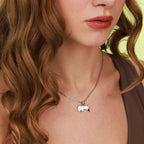 A woman wearing a necklace with a small polished bull pendant
