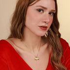 Woman wearing a gold necklace with a bull pendant against a beige background