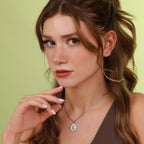 Woman wearing a christian necklace against a green background