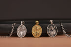Three Good Shepherd pendants on chains against a dark background