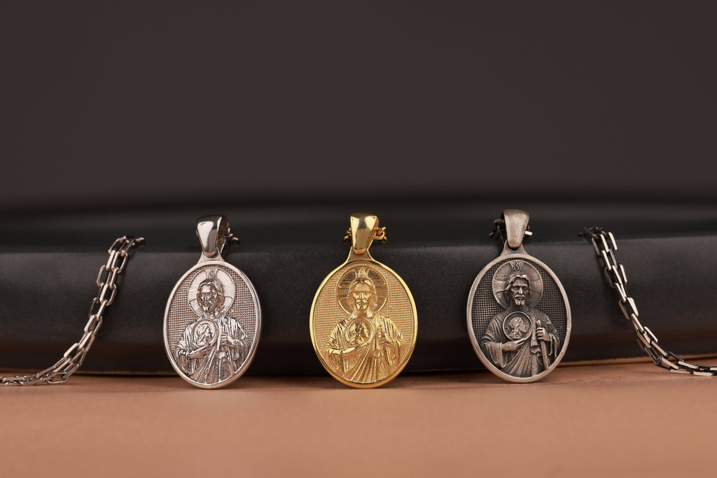 Three religious pendants on chains against a black and brown gradient background
