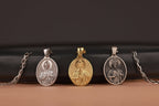 Three religious pendants on chains against a black and brown gradient background