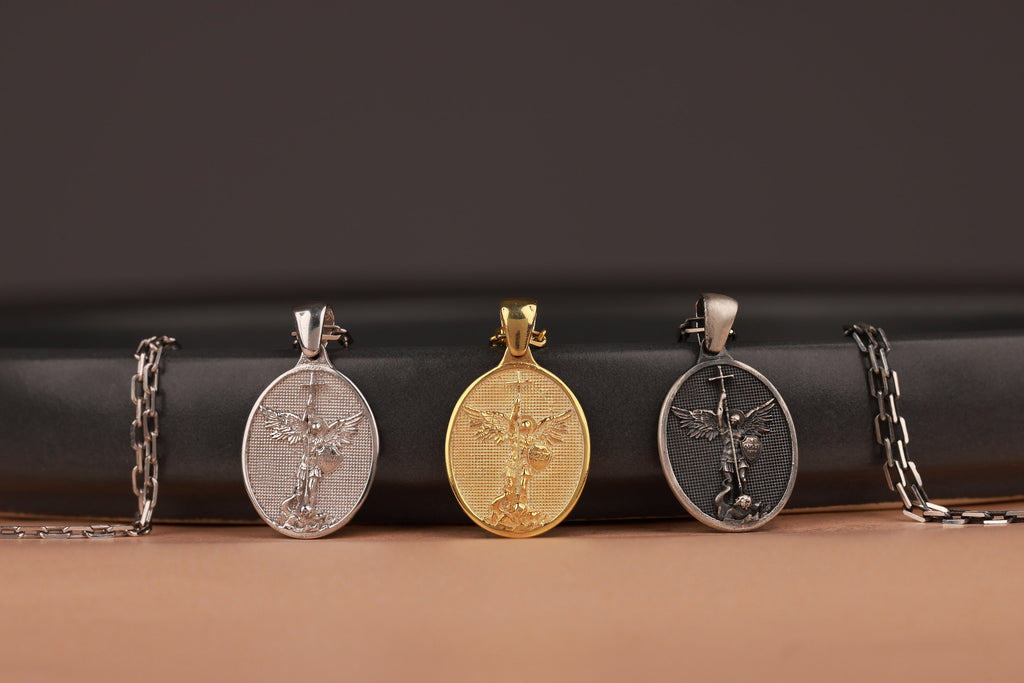 Three St Michael the Archangel pendants on a black and brown gradient background
