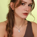 Woman wearing a polished jesus necklace with a yellow background