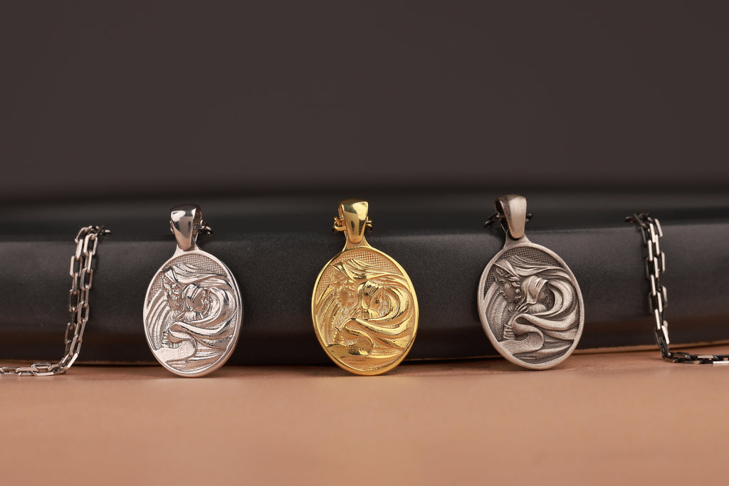Three oval-shaped Mother Mary pendants on a black cylindrical object with a brown background