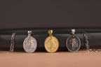 Three risen Jesus pendants on chains against a dark background