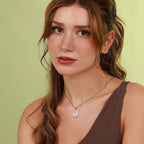 Woman wearing a mother mary necklace against a green background