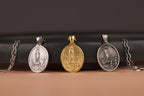 Three religious Our Lady of fatima pendants on chains against a black and brown gradient background