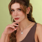 Woman wearing a polished virgin mary necklace with a green background