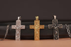 Three resurrection cross pendants on a dark surface with a brown background