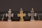 Three cross-shaped pendants on a dark background