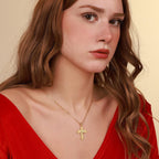 Woman wearing a gold vermeil necklace with a St Michael cross pendant against a beige background