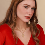 A woman wearing a gold necklace with a cross pendant with the "Only God Can Judge Me" 