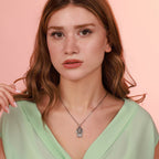 Woman wearing an oxidized necklace against a pink background