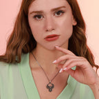 Woman wearing a phoenix necklace with a pink background