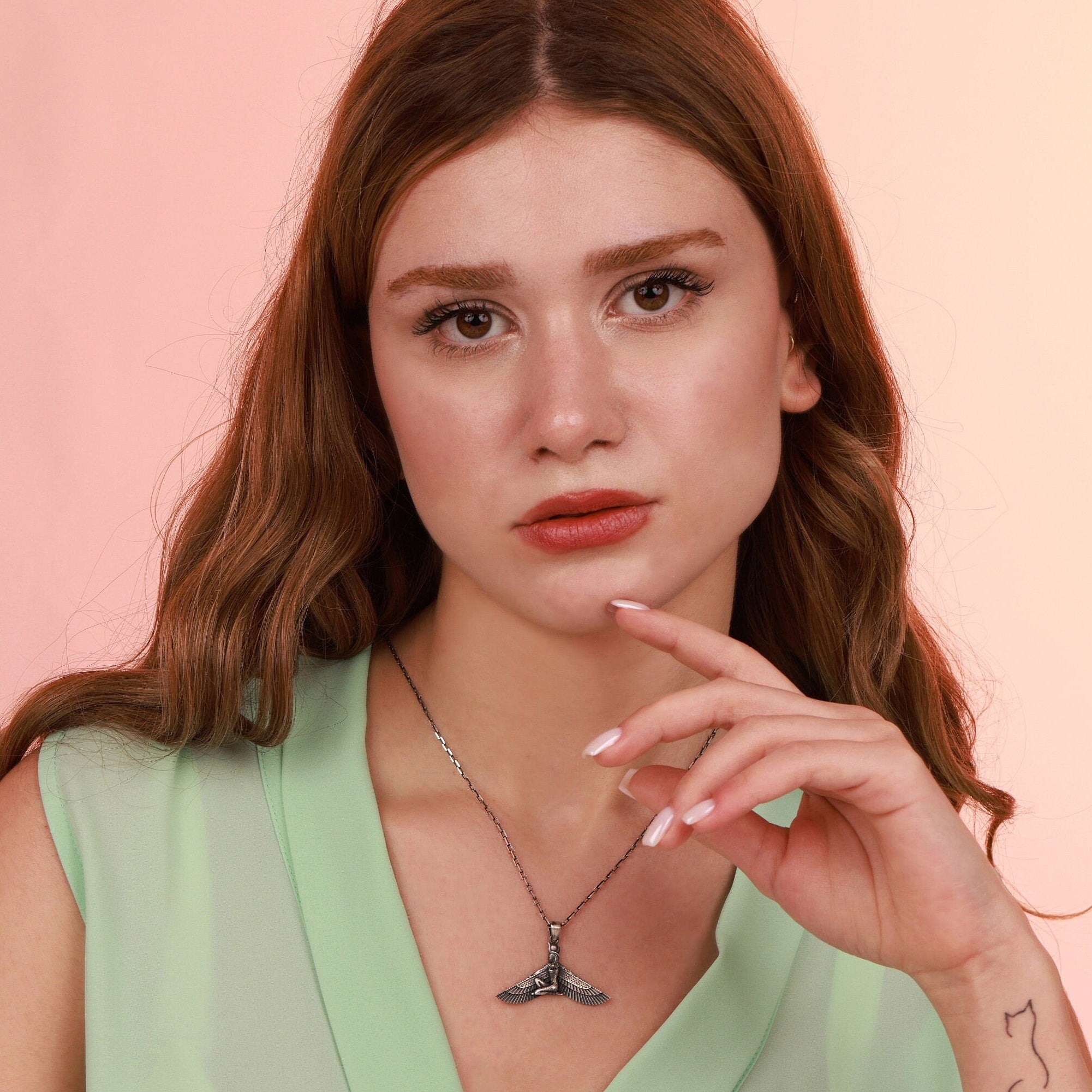 Woman wearing an oxidized necklace with a pink background