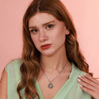 Woman wearing a silver necklace against a pink background